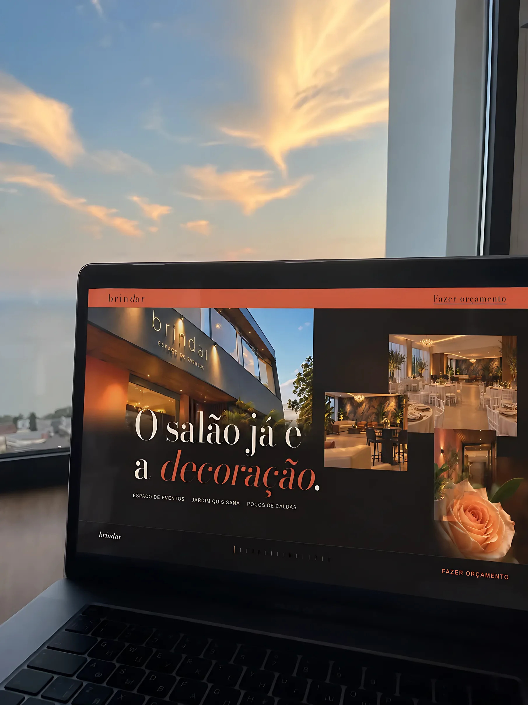 Site da Brindar aberto num notebook diante de uma janela ao pôr do sol.