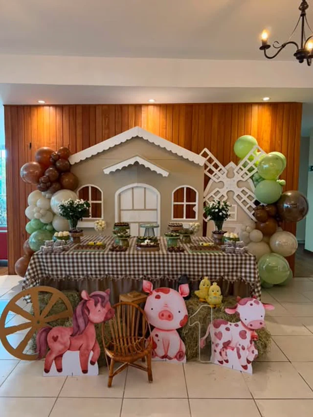 Festa infantil no Brindar com cenário de fazendinha, balões verdes e bichinhos de pelúcia.